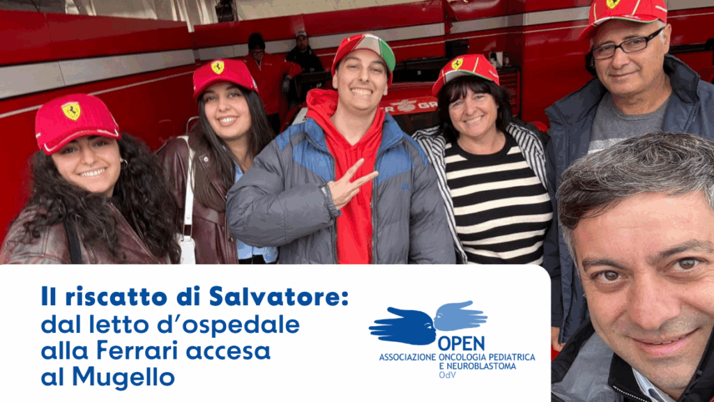 Salvatore insieme ai familiari e agli accompagnatori nel box Ferrari al Mugello, tutti con cappellini rossi Ferrari, durante l’esperienza organizzata dall’associazione OPEN OdV.